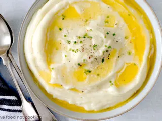 A bowl of Instant Pot mashed potatoes with butter melting on top.