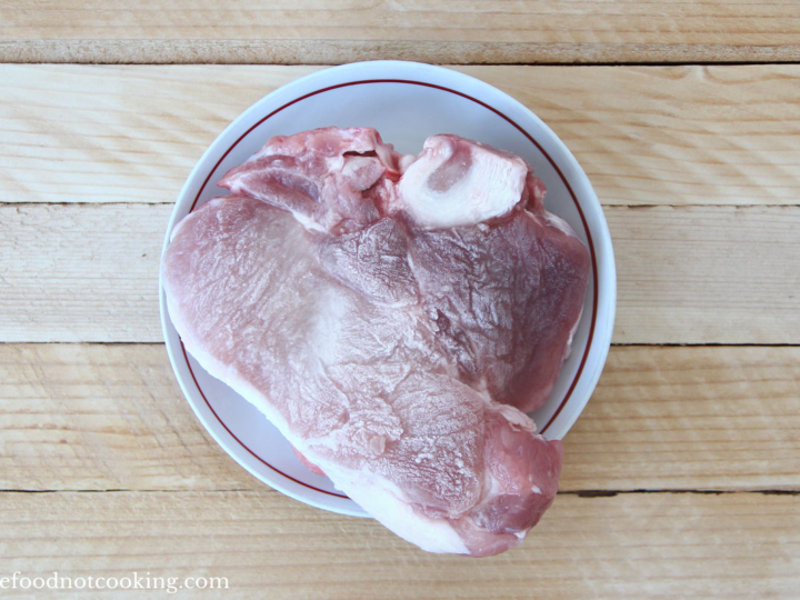 Frozen pork roast in a white bowl.