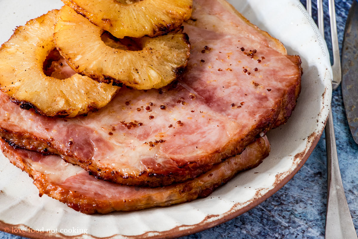 Air fried ham steaks with grilled pineapple on a white plate.