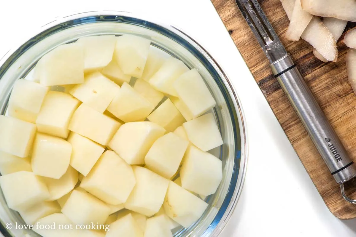 Diced potatoes soaking in a bowl of water. 