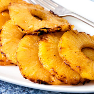 Air fryer pineapple slices on a white plate.