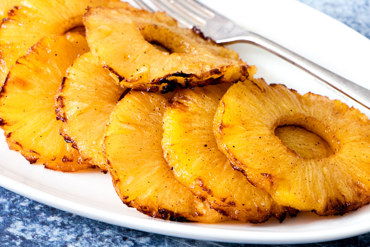 Air fryer pineapple slices on a white plate.