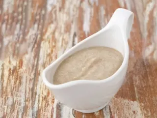 Cream of mushroom soup gravy in a white gravy boat.