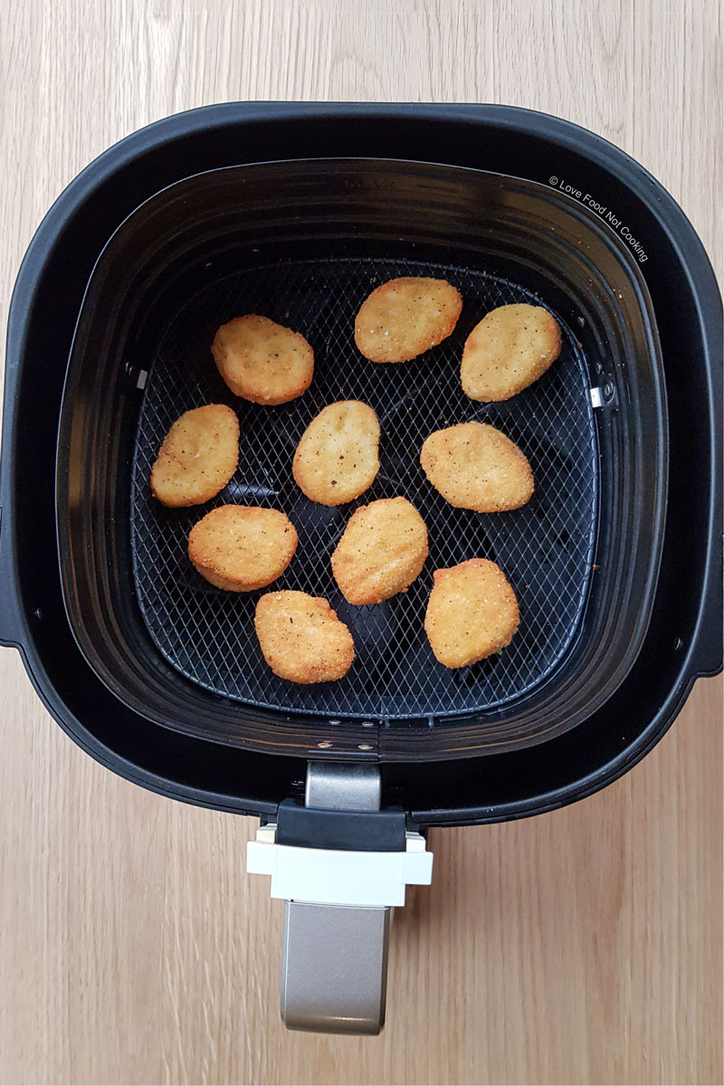 Air fried chicken nuggets in the air fryer basket. 