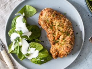 Air fryer chicken cutlet on a blue plate with salad.