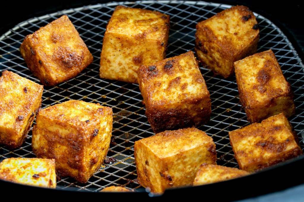 Crispy air fried tofu in air fryer basket. 