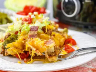 Crock pot tater tot casserole on a white plate with salad.