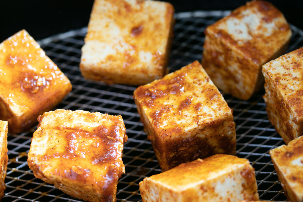 Uncooked tofu in air fryer basket.