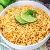 Instant Pot Spanish rice in a white bowl garnished with sliced limes.