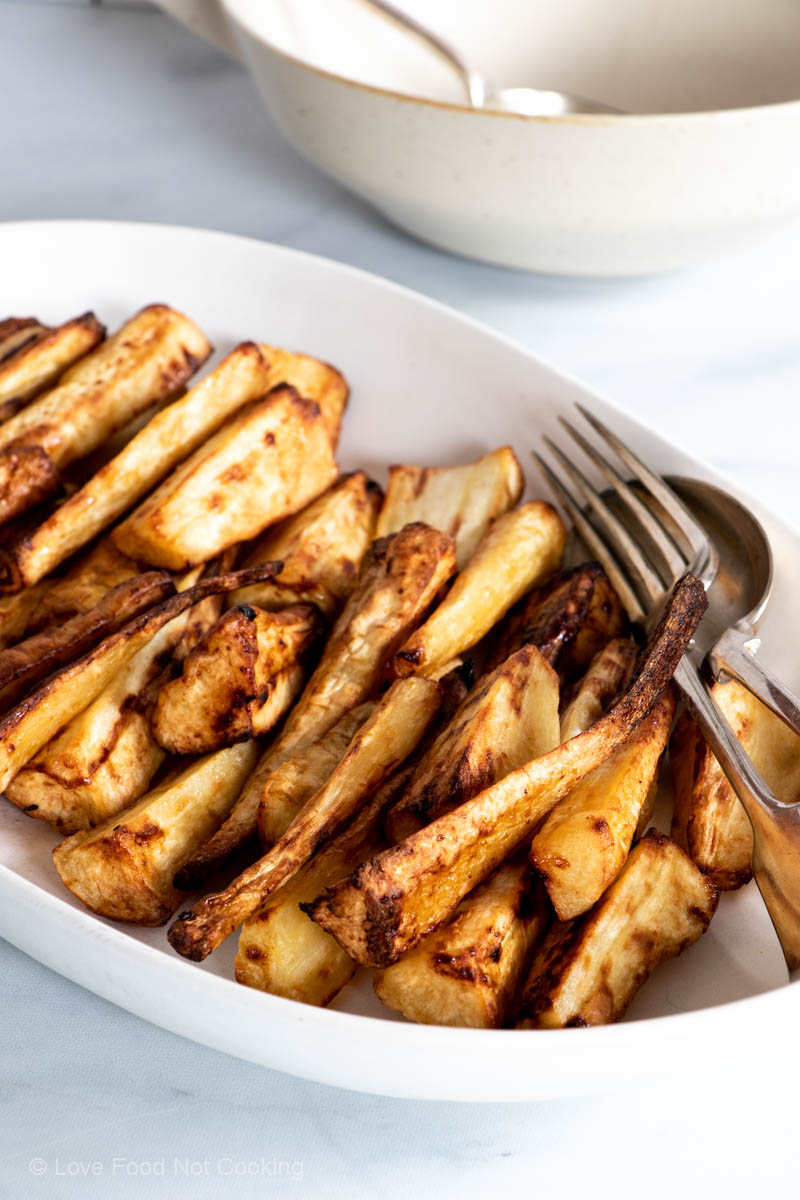 Air fryer honey-roasted parsnips on a white dish. 