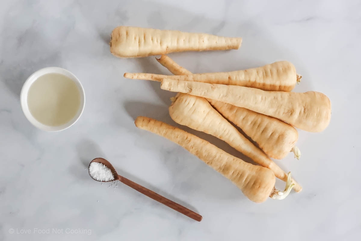 A flat-lay image of the ingredients for this air fryer roasted parsnips recipe. 