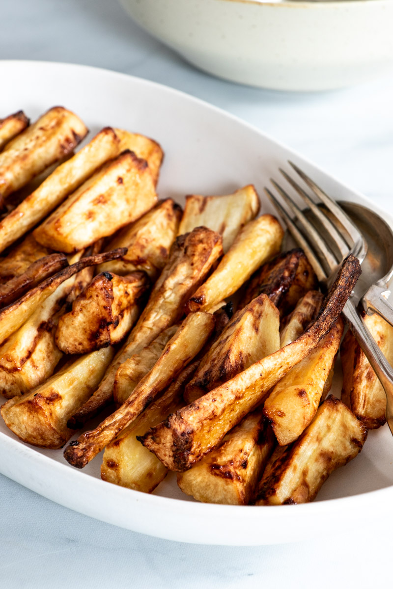 Air fried parsnips on a white serving dish.