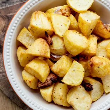 Crispy air fryer roast potatoes in a white serving dish.