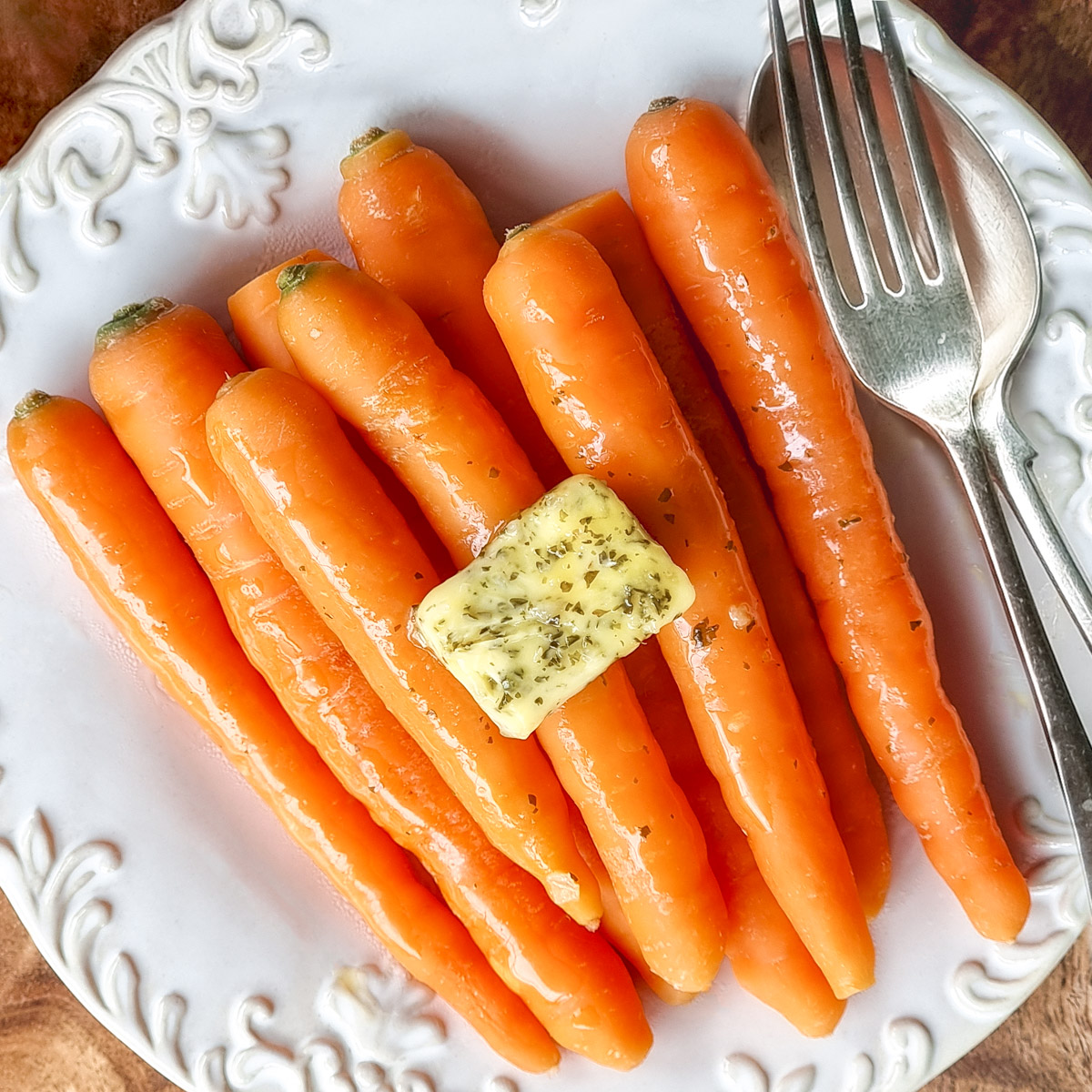 Microwave steamed carrots on a white plate.