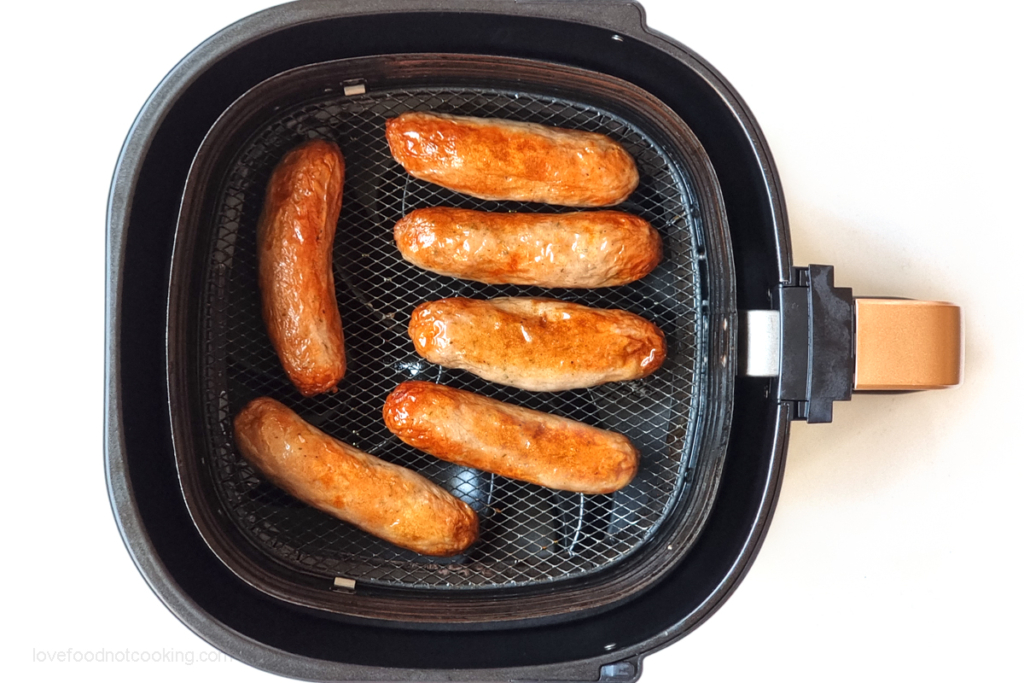 Air fried sausages in air fryer basket.