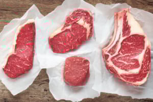 Four cuts of steak on butchers paper.