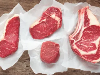 Four cuts of steak on butchers paper.