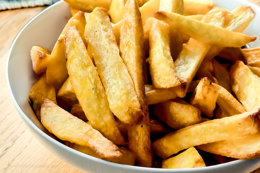 Air fried french fries in a white bowl.