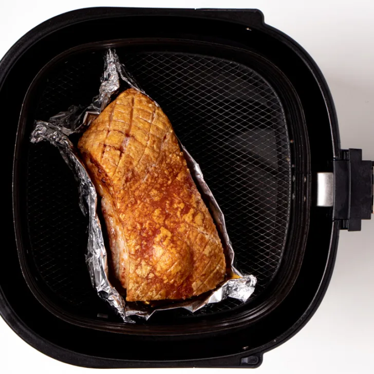 Air fried pork belly in air fryer basket. 
