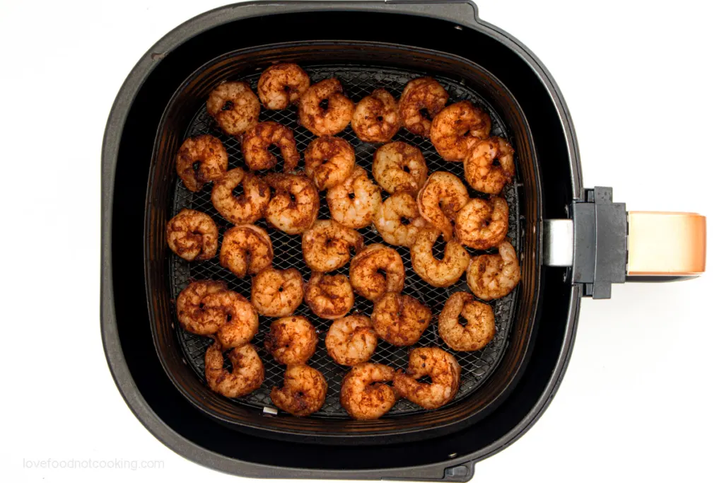 Air fried shrimp in air fryer basket.