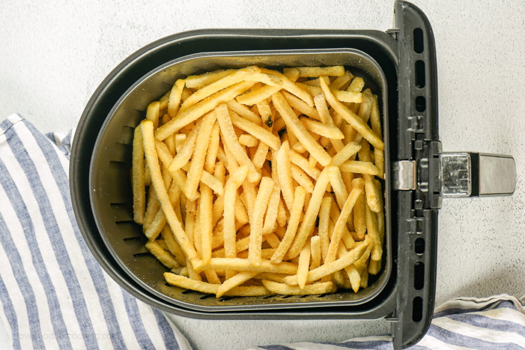 Frozen french fries in air fryer basket. 