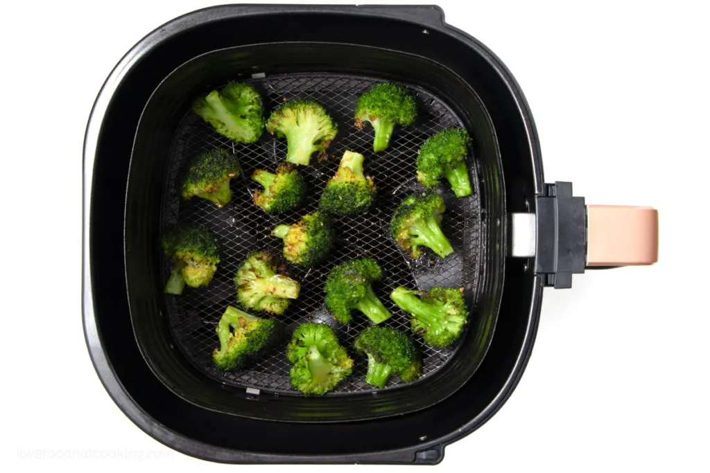 Air fried broccoli in air fryer basket. 