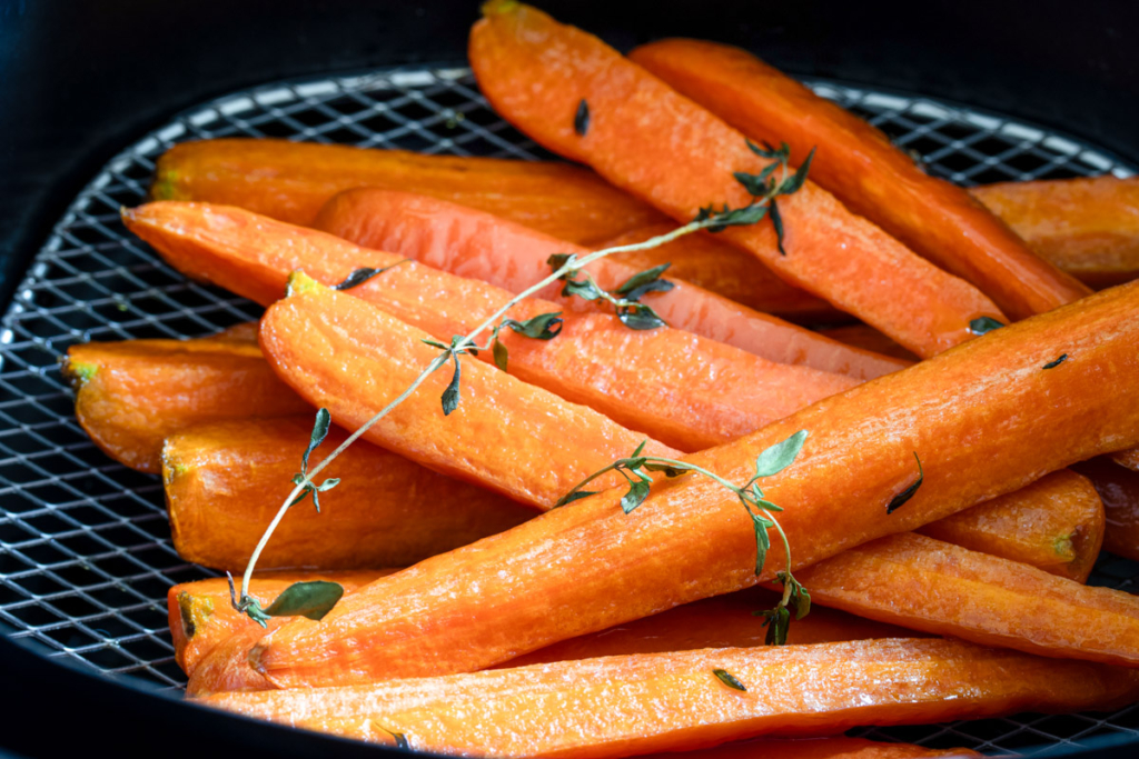 Air fried carrots in air fryer basket.