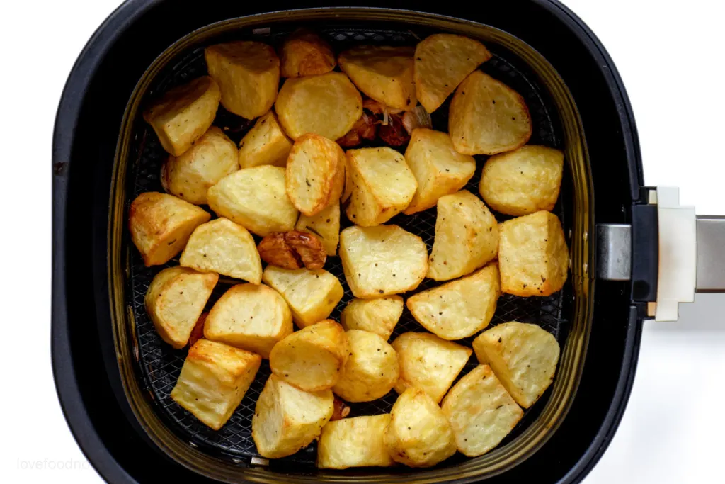 Cooked roast potatoes in air fryer basket. 