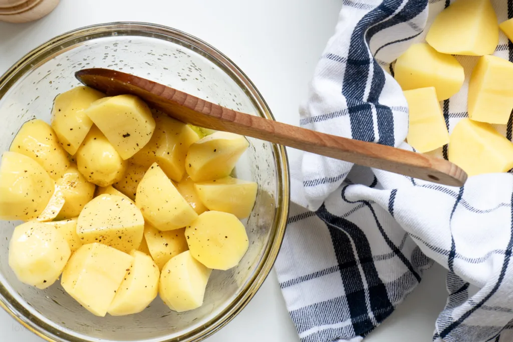 Cut potatoes on a dish towel and in a bowl.