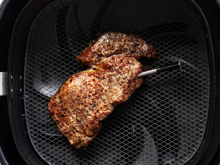 Steak in air fryer basket.