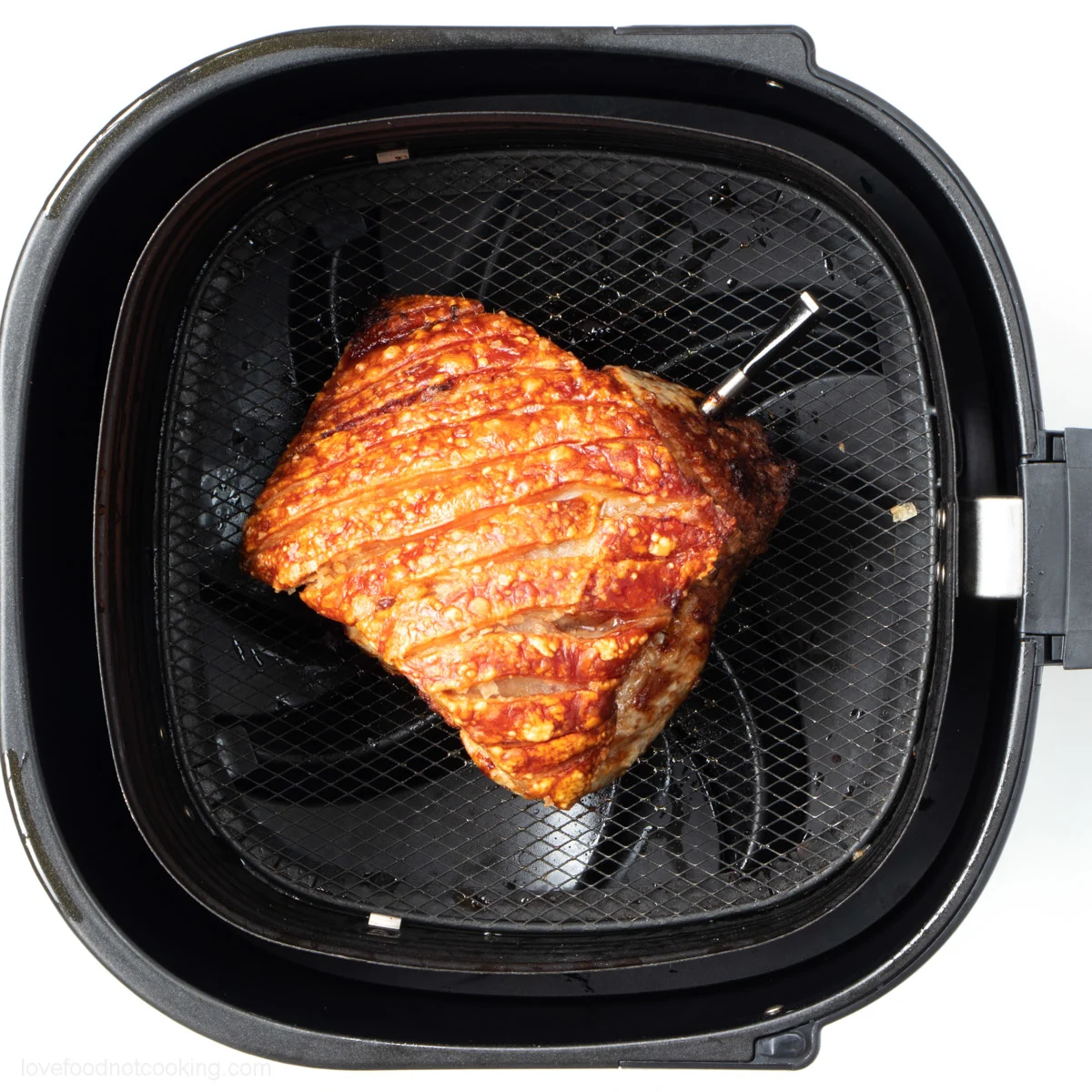 Air fried pork roast in air fryer basket.
