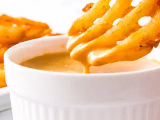 A bowl of homemade Chick-fil-a sauce with waffle fries.