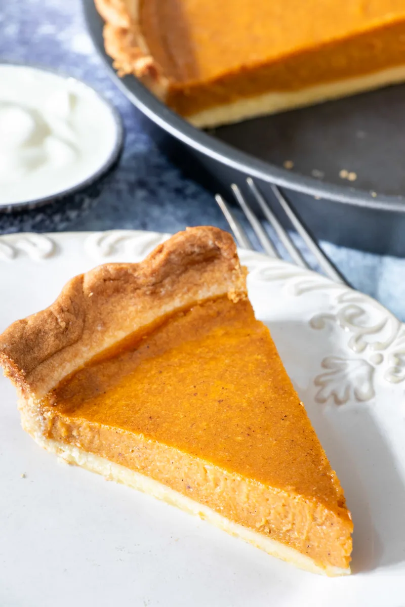 A slice of air fried pumpkin pie on a white plate.