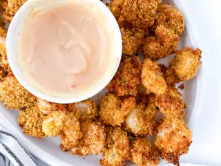Air fryer popcorn shrimp on a white plate.