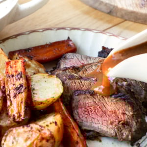 Pouring gravy over air fryer pot roast.