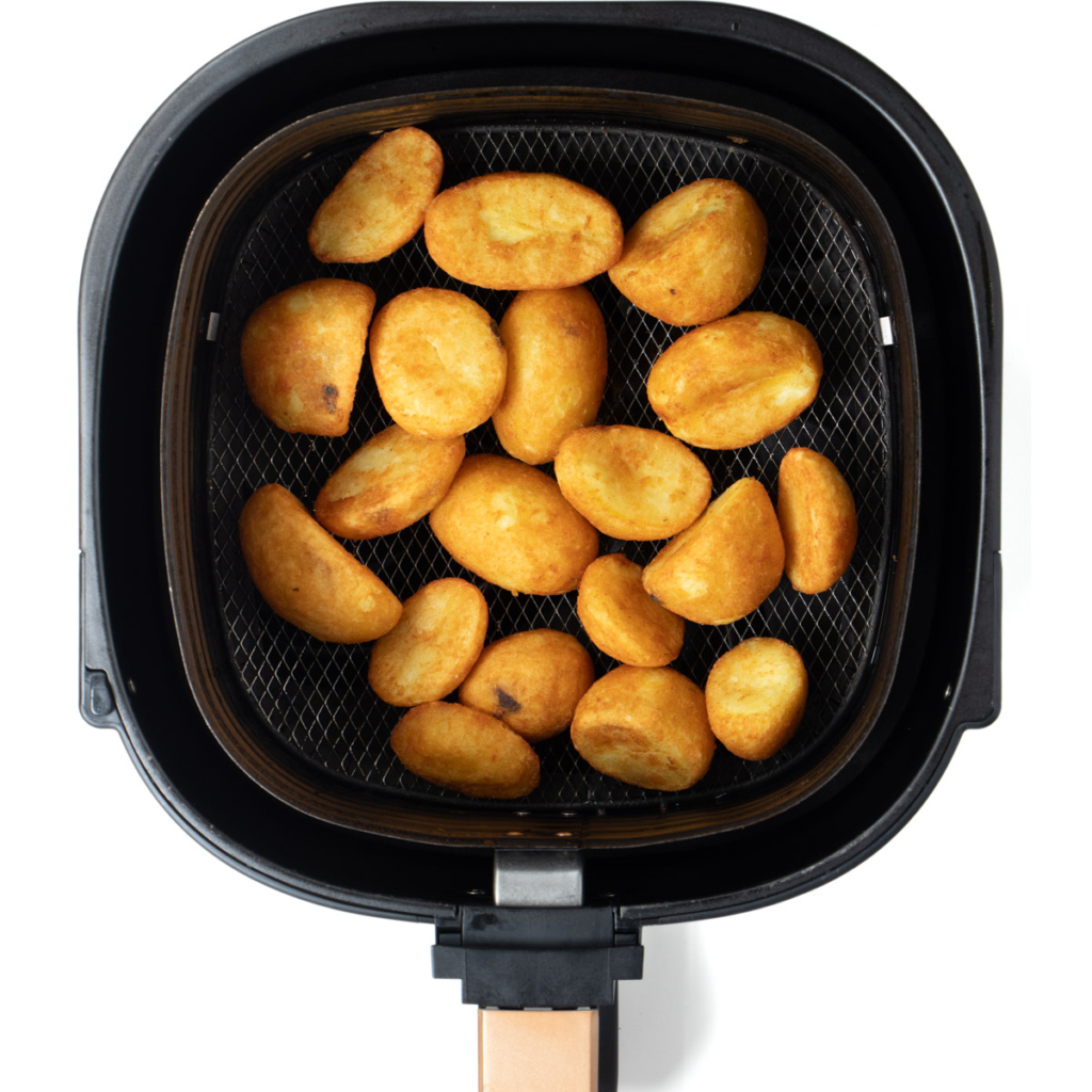 Air fried frozen roast potatoes in air fryer basket.