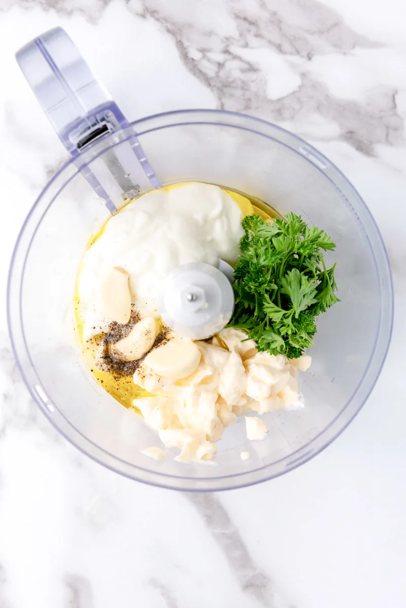 Creamy garlic dip ingredients in a blender bowl. 