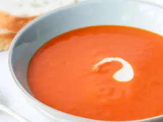 Creamy tomato soup made with canned tomatoes, in a blue bowl.