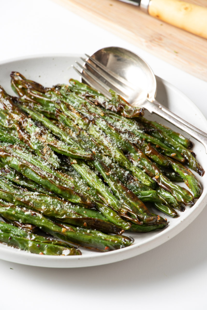 Air fried green beans on a white plate.