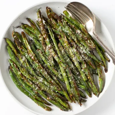 Air fryer green beans on a white plate.
