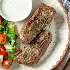 Air fryer lamb steaks on a plate with salad.