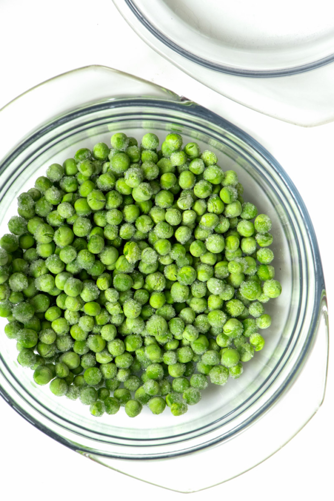 Frozen peas in microwave safe bowl.