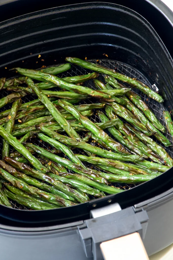 Green beans in air fryer basket. 