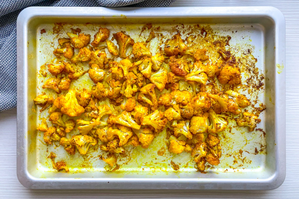 Spicy roasted cauliflower on a baking tray.