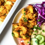 Spicy roasted cauliflower on plate with salad.