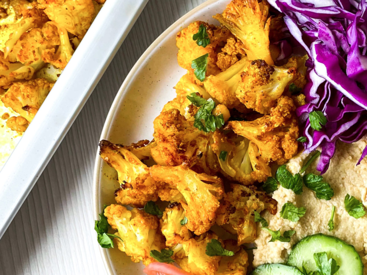 Spicy roasted cauliflower on plate with salad.