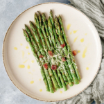 Flat lay image of air fryer asparagus on a white plate.