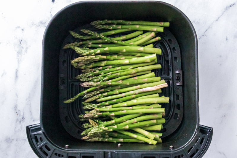 Asparagus in air fryer basket. 