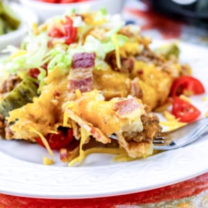 Crock pot tater tot casserole on a white plate with salad.