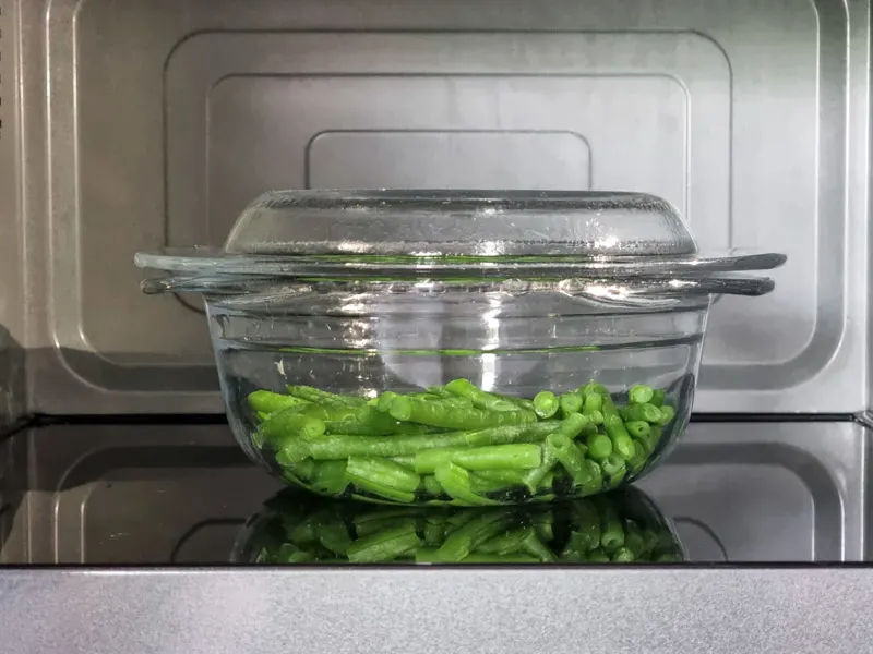 Bowl of green beans in microwave.